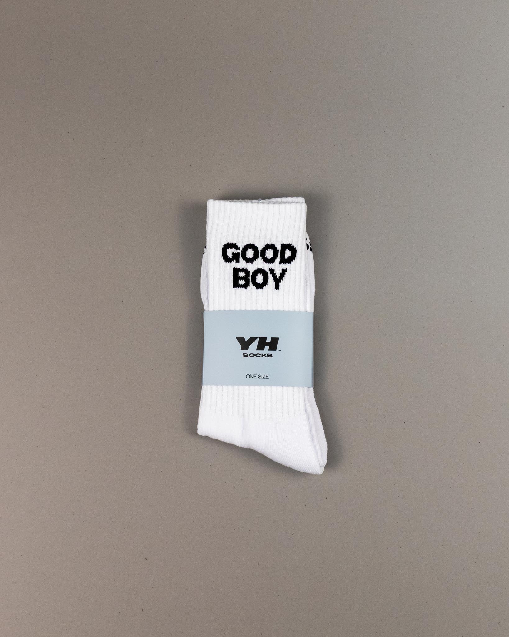 White sock with 'GOOD BOY' text and a label on a gray background