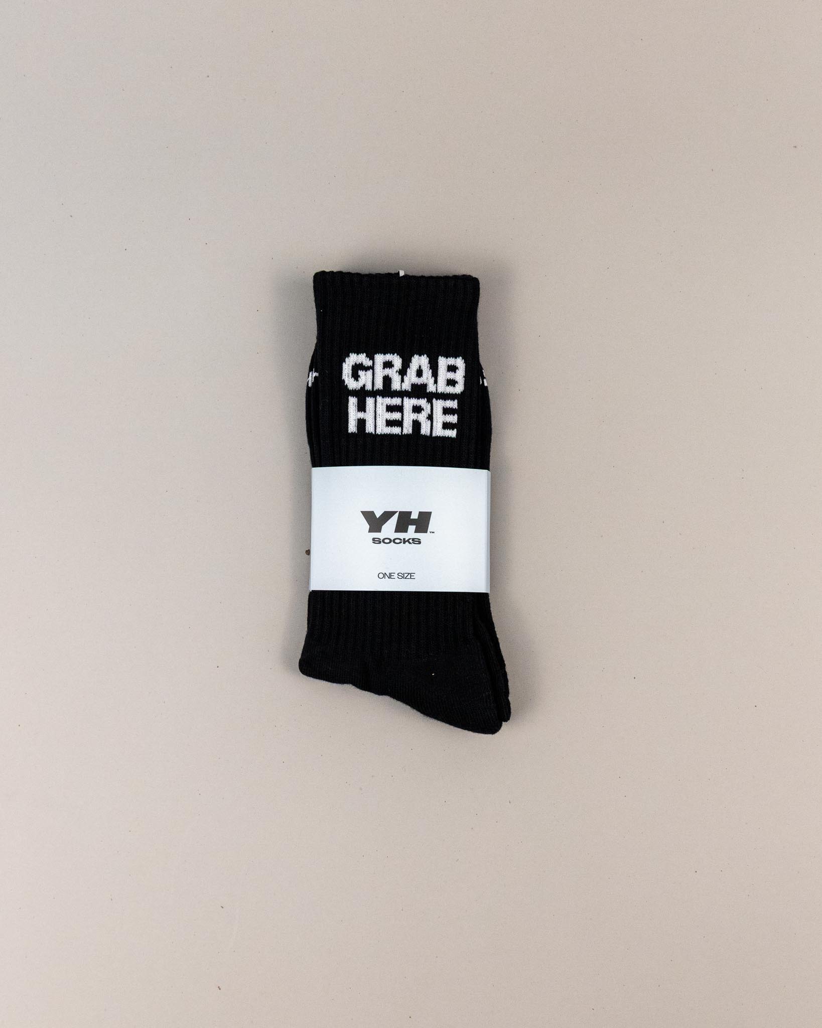 Black sock with 'GRAB HERE' text on a beige background