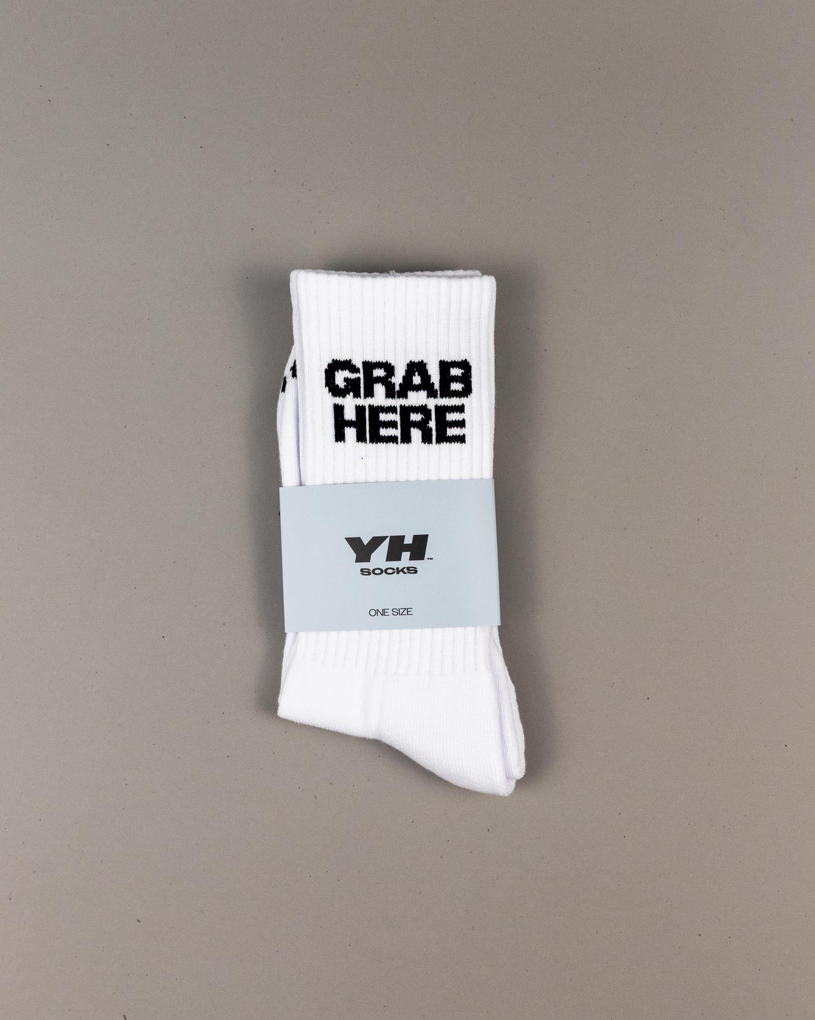 White socks with 'GRAB HERE' text and a blue band on a gray background