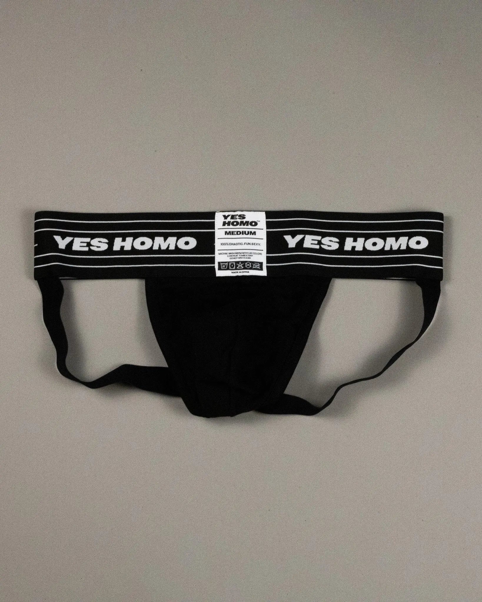Black men's underwear with 'YES HOMO' label on a gray background