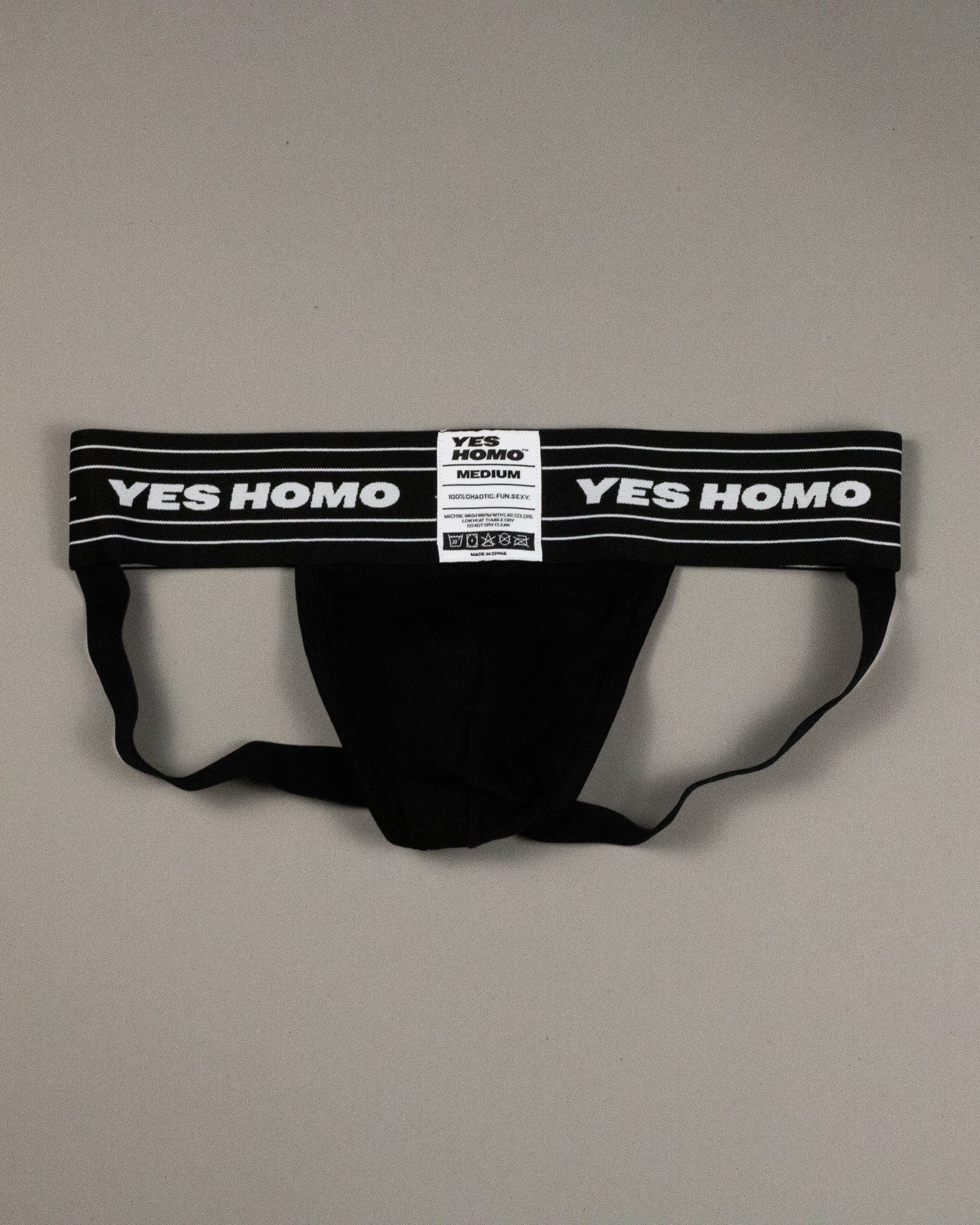 Black men's underwear with 'YES HOMO' label on a gray background